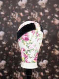 Floral-patterned headband on a mannequin head against a floral background
