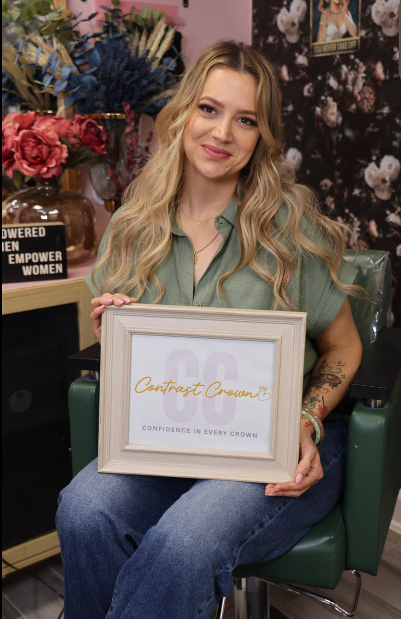 Woman holding a framed quote in a floral-themed room