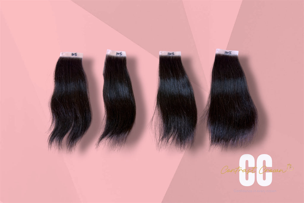 Four bundles of black hair extensions on a pink background