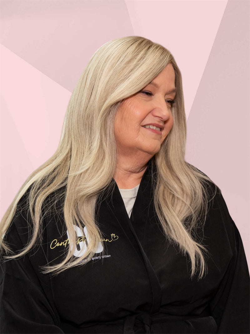Woman with long blonde hair wearing a black robe with gold text on a pink geometric background