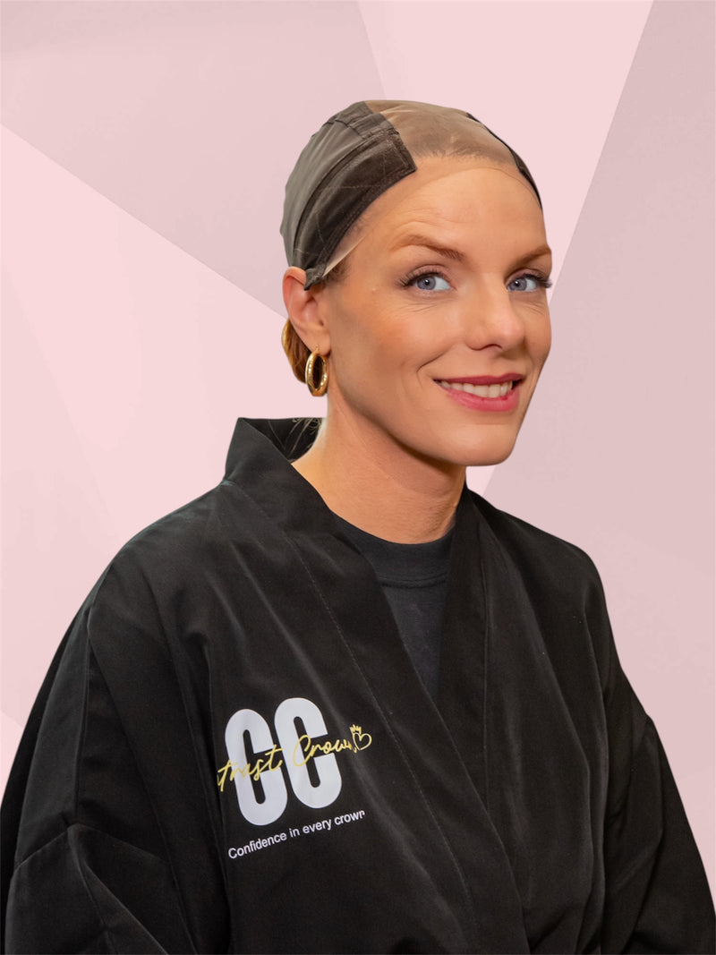 Woman wearing a black sweatshirt with text on a pink geometric background