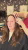 Hairdresser styling hair on client